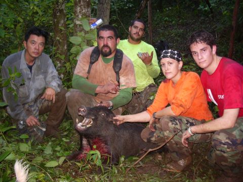 1991 Ford Bronco - A group of hunters proudly display their kill, a wild boar, in a wooded area.