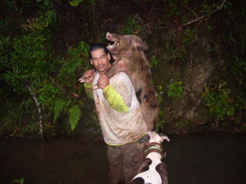 1991 Ford Bronco - Hunter carries a wild boar he has caught, accompanied by his dog.