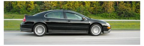 2002 Chrysler 300M - Side view of a black 2002 Chrysler 300M in motion on a highway.