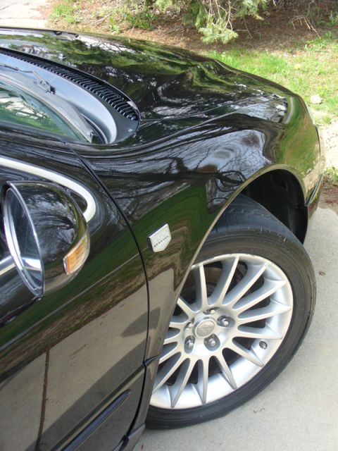 2002 Chrysler 300M - Close-up of a black 2002 Chrysler 300M's front fender and alloy wheel.