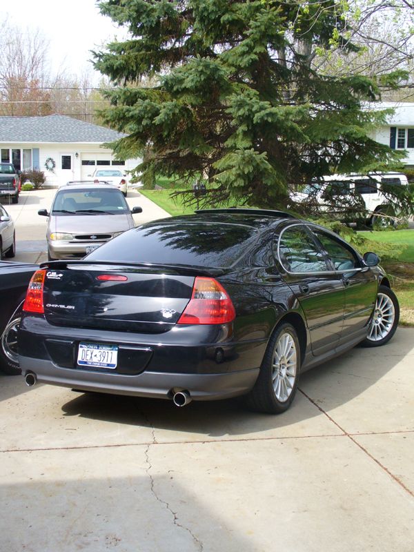 Black Chrysler 300M parked in a driveway with a minivan and SUV in the background