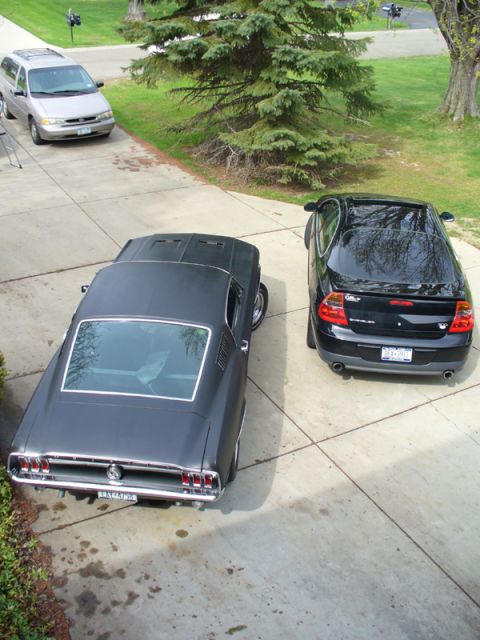 2002 Chrysler 300M - Rear view of a black sedan with dual exhaust pipes and a spoiler.