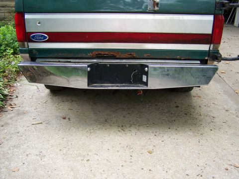 1989 Ford Bronco - The rear of a green Ford pickup truck, showing the tailgate, bumper, and a portion of the taillight.