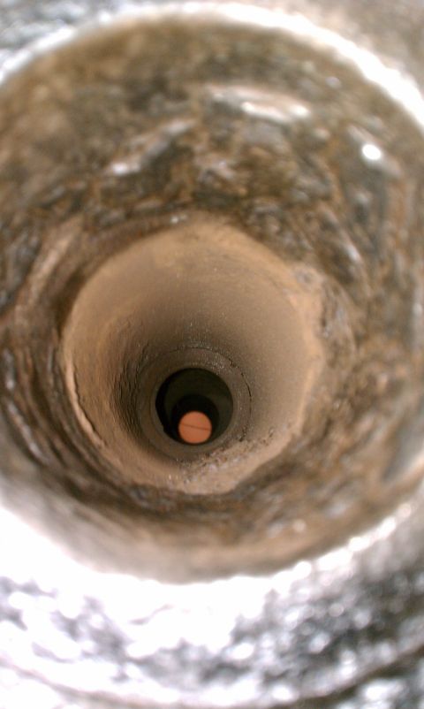 1990 Ford Bronco - Interior view of a vehicle's exhaust pipe, showing the narrow passage.