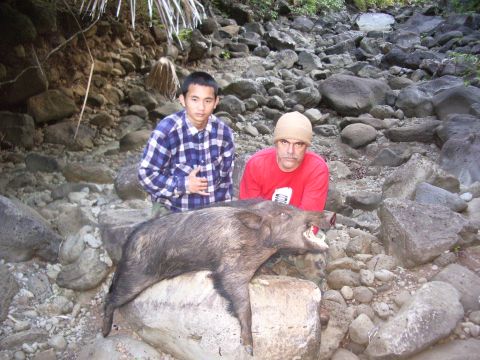 1991 Ford Bronco - Hunters pose with their wild boar kill in a , outdoor setting.