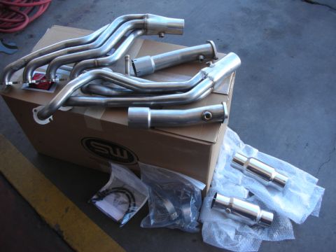 2004 Ford Crown Victoria - A new stainless steel cat-back exhaust system laid out on and around a cardboard SW shipping box on a garage floor, with mandrel-bent tubin…