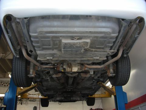 2004 Ford Crown Victoria - Undercarriage of a 2004 Ford Crown Victoria on a lift, highlighting the exhaust and suspension components.
