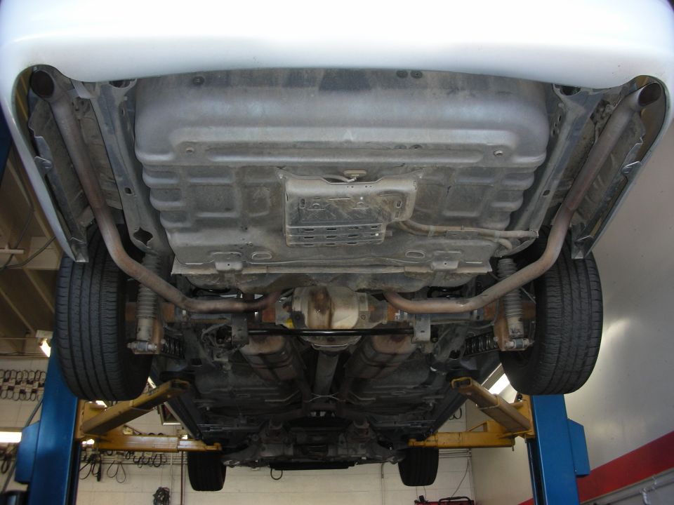 Undercarriage view of a 2004 Ford Crown Victoria showing exhaust system and rear axle