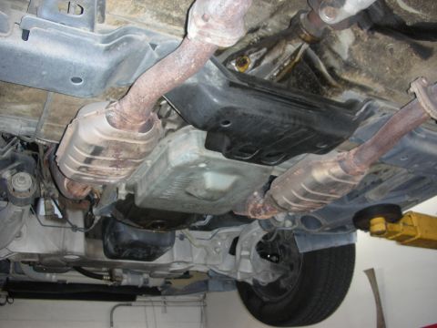 2004 Ford Crown Victoria - The undercarriage of a vehicle is visible, the exhaust system and transmission components.