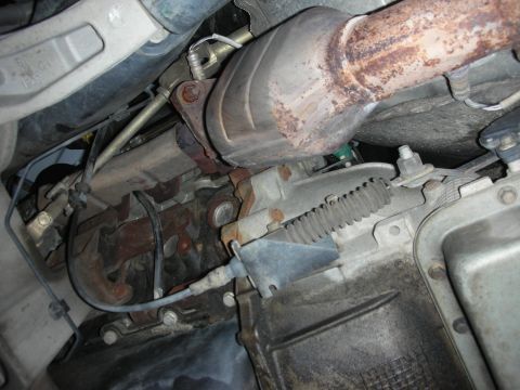 2004 Ford Crown Victoria - Close-up of the exhaust system and transmission components, showing signs of wear and rust.