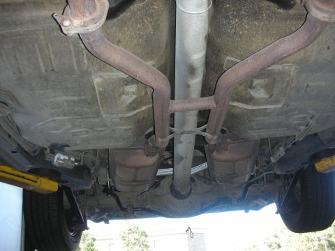 2004 Ford Crown Victoria - The undercarriage of a vehicle is shown, focusing on the exhaust system components.