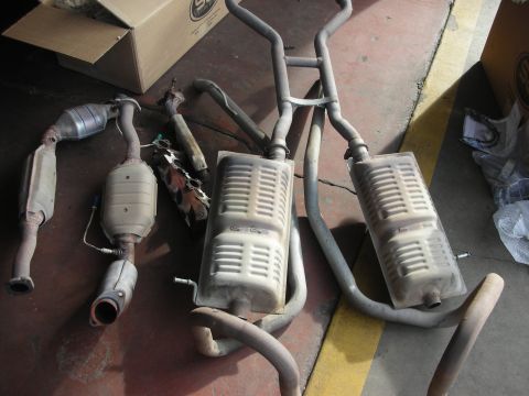 2004 Ford Crown Victoria - Various exhaust system components are displayed on a workshop floor.