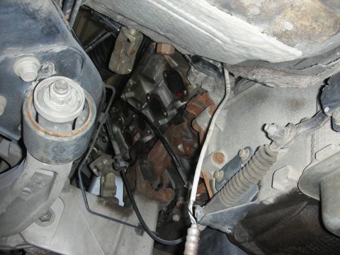 2004 Ford Crown Victoria - Close-up view of the engine bay, focusing on the exhaust system and transmission connections.