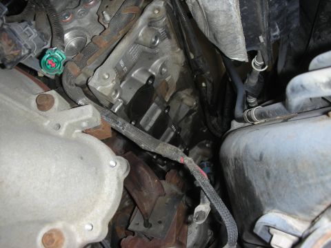 2004 Ford Crown Victoria - Close-up view of engine components, including wiring and exhaust parts.