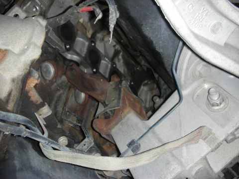 2004 Ford Crown Victoria - Close-up view of engine bay components, focusing on exhaust headers and associated wiring.