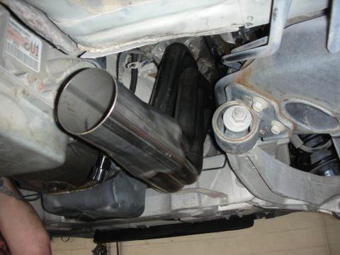 2004 Ford Crown Victoria - Underside view of a vehicle's exhaust system, showing a new pipe and suspension parts.