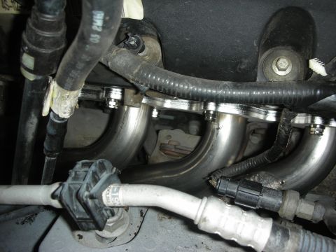 2004 Ford Crown Victoria - Close-up view of stainless steel long tube headers installed in an engine bay.