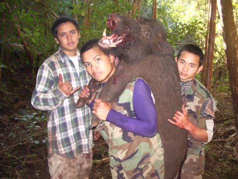 1991 Ford Bronco - Hunters pose with a large wild boar they have killed in a forest.