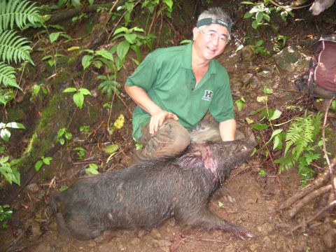 1991 Ford Bronco - Man poses with a wild boar he apparently hunted in a wooded area.