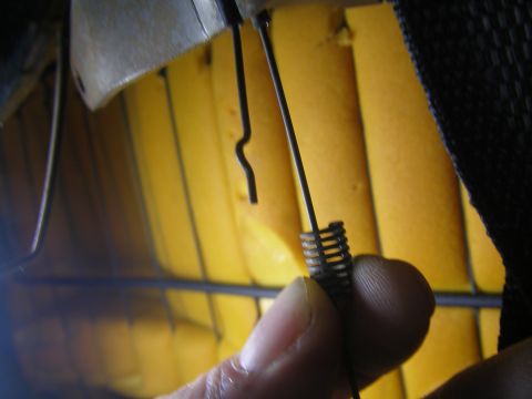 1990 Ford Bronco - Close-up of a seat's internal spring mechanism being held by a hand.