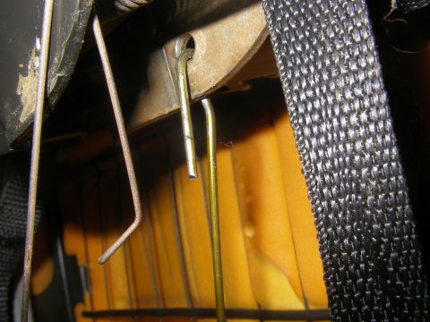 1990 Ford Bronco - Detail of the internal mechanism for adjusting a vehicle seat, showing metal rods and fabric.