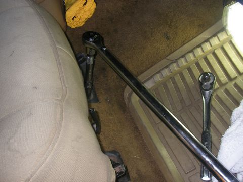 1990 Ford Bronco - A close-up shot of the interior of a vehicle, focusing on a tan seat and the floor where two socket wrenches are placed.