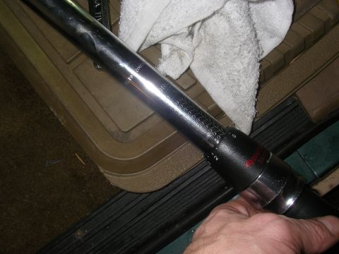 1990 Ford Bronco - Torque wrench with visible measurement markings, held by a hand.