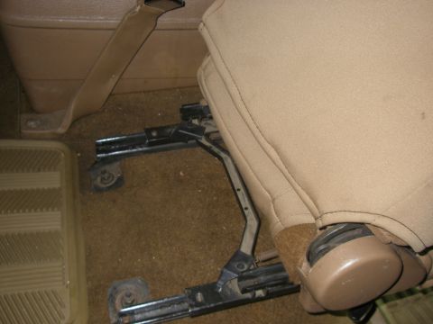 1990 Ford Bronco - The intricate slider mechanism beneath a vehicle's seat is shown in this interior shot.