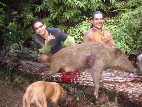 1991 Ford Bronco - Hunters celebrate their successful wild boar hunt, posing with their catch and a dog, with a watermark visible.