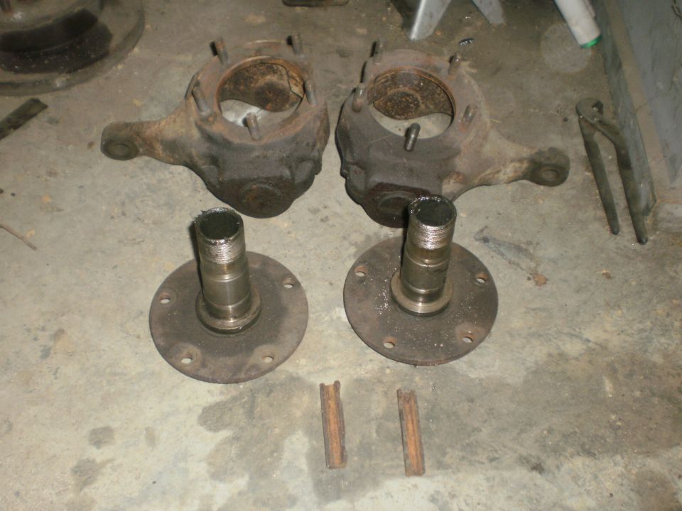 Pair of front wheel hubs and steering knuckles on concrete floor