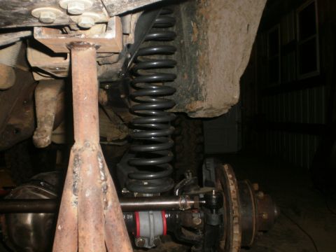 1995 Ford Bronco - Close-up view of vehicle suspension parts, including a coil spring and a jack stand, with a "Supermotors.net" watermark visible.