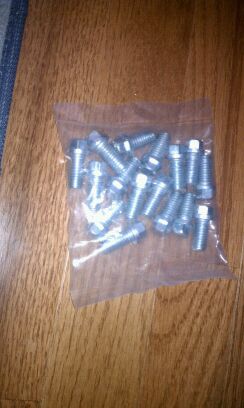 1996 Ford Bronco - A plastic bag filled with numerous bolts rests on a wooden surface, with a SUPERMOTORS.NET logo visible at the bottom.