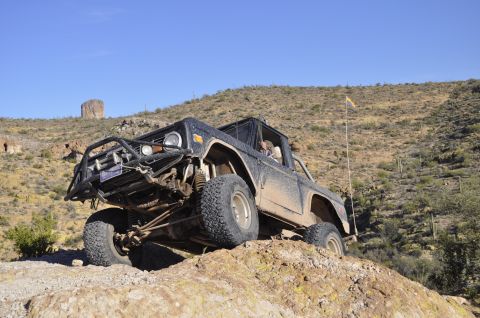 1991 Ford Bronco - This modified Ford Bronco navigates a steep, rocky incline under a clear blue sky.