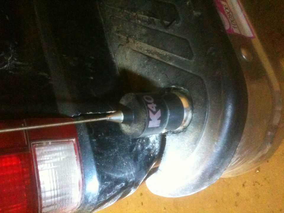 Close-up of a K40 antenna mount on a vehicle's rear bumper, next to a taillight
