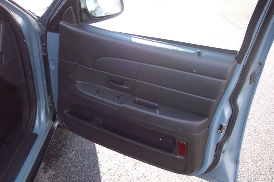 Interior of a car door showing the panel, window controls, and door handle