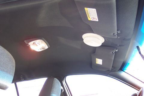 2001 Ford Crown Victoria - Interior view of a vehicle's ceiling, showing lights and sun visors with warning labels.