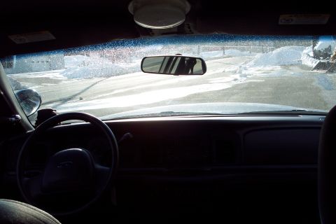 2001 Ford Crown Victoria - Interior view of a 2001 Ford Crown Victoria police car, showing the dashboard, steering wheel, and a glimpse of the exterior through the wi…
