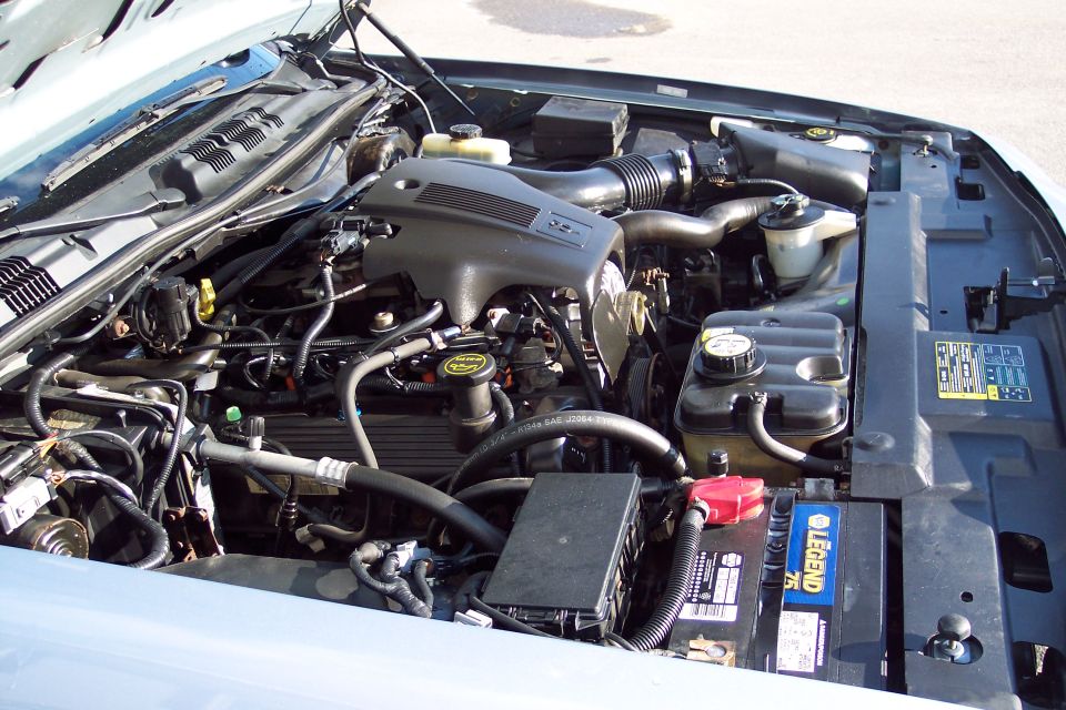 Engine bay of a 2001 Ford Crown Victoria. Shows the V8 engine, battery, and various hoses and components