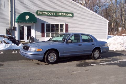 2001 Ford Crown Victoria - Blue 2001 Ford Crown Victoria parked in front of a commercial building with snow piles nearby.