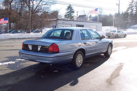 2001 Ford Crown Victoria - A light blue 2001 Ford Crown Victoria is seen from the rear on a sunny winter day.