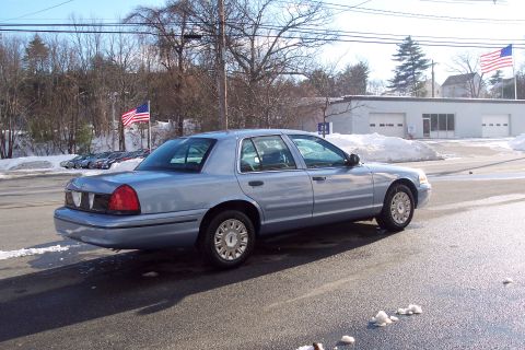 2001 Ford Crown Victoria - A light blue 2001 Ford Crown Victoria sedan is parked on a street with snow on the ground.