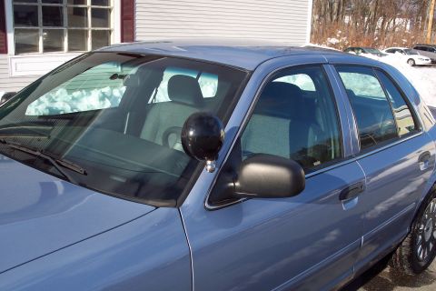 2001 Ford Crown Victoria - A blue 2001 Ford Crown Victoria is shown from the front passenger side, a spotlight mounted on the fender.