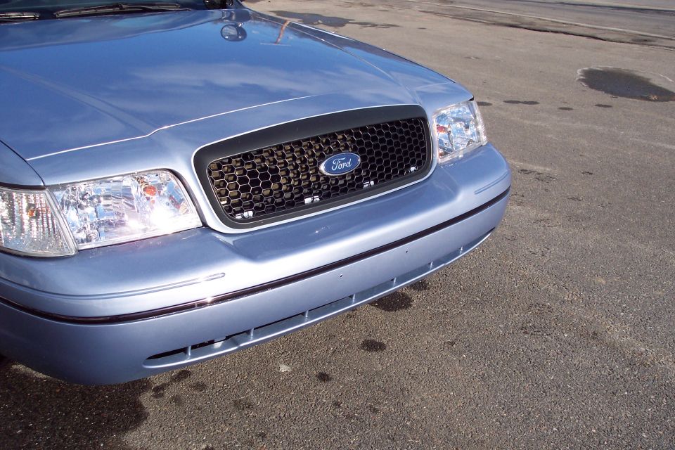 Light blue Ford Crown Victoria front end with honeycomb grille and Ford logo