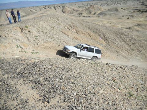 1997 Ford Ranger - A white SUV navigates a steep, rocky incline in a desert landscape.
