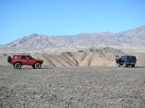 1997 Ford Ranger - Two SUVs are parked in a desert landscape with mountains in the distance.