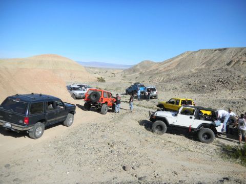 1997 Ford Ranger - A group of off-road vehicles are parked in a desert landscape under a clear blue sky.