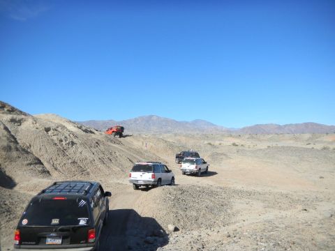 1997 Ford Ranger - Multiple vehicles navigate a dusty desert trail under a clear blue sky.