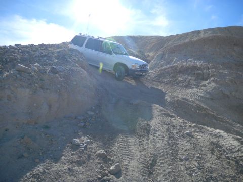 1997 Ford Ranger - A white 1997 Ford Ranger navigates a challenging off-road terrain on a sunny day.