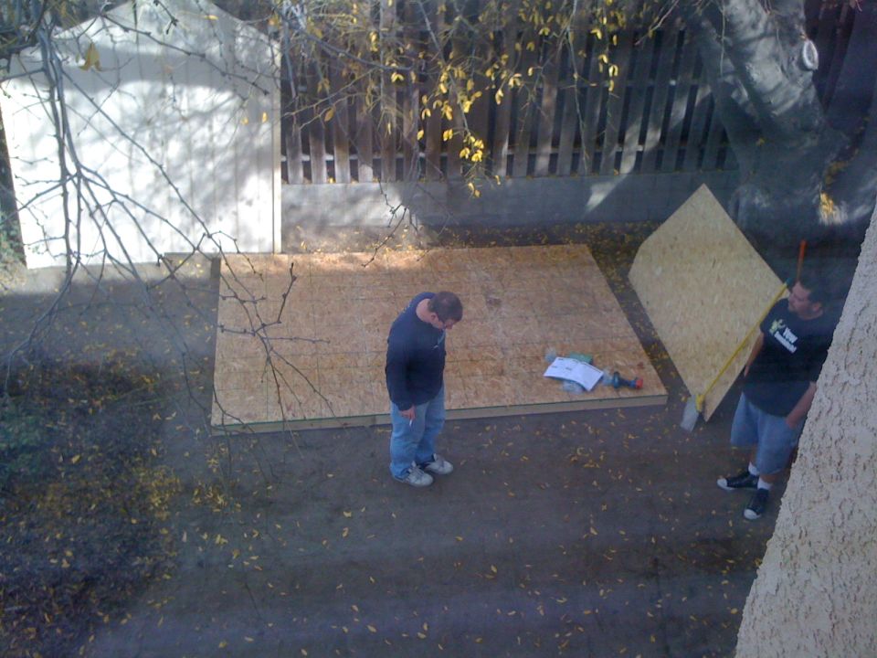 Two men working with plywood sheets outdoors