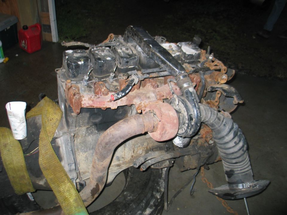 Rusty diesel engine with turbo and exhaust manifold, strapped for transport